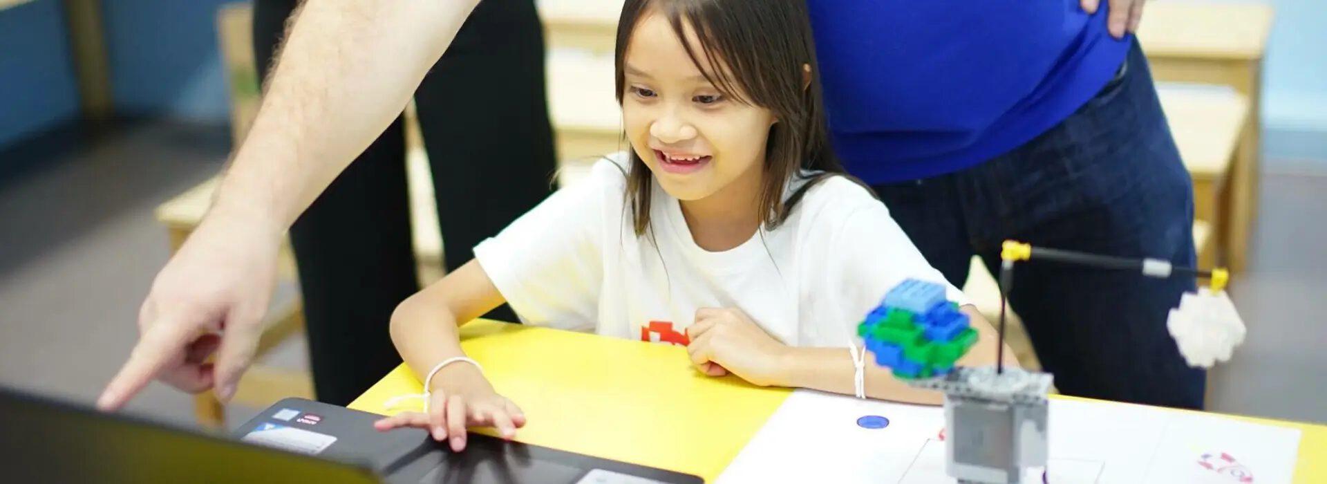 Children coding on laptops in a Bricks 4 Kidz robotics class
